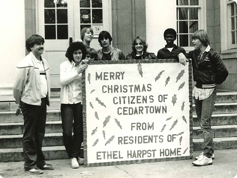 Historical photo of residents with Christmas sign